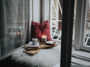 photo of a cozy reading nook with a candle and coffee
