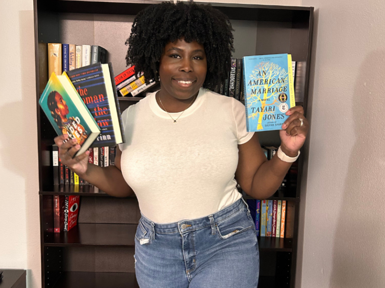 photo of kathleen haagenson holding a selection of books in both hands that represent the best book genres for spring