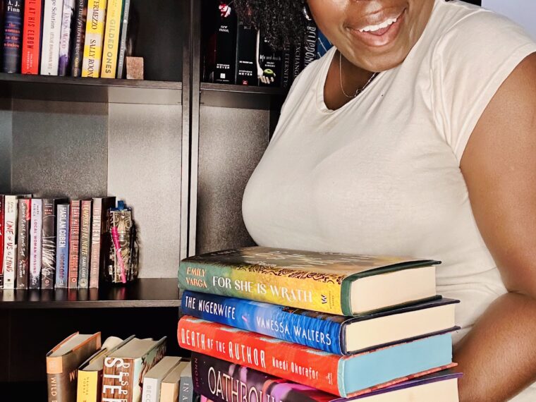 kathleen Haagenson holding a stack of books from 2025 april tbr