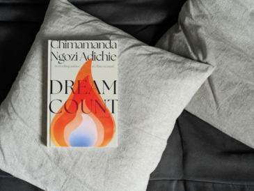 book dream count by chimamanda ngozi adichie on a throw pillow on a couch