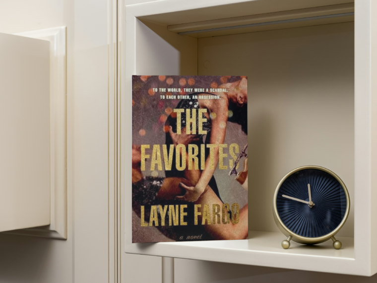 the favorites by Layne Fargo sitting on a bookshelf with a gold clock