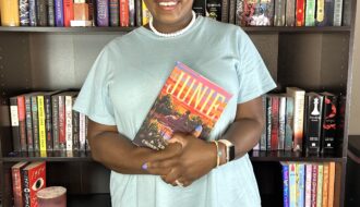 kathleen haagenson holding the book junie while posing in front of bookshelves for juneteenth vibes