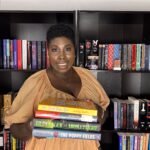 photo of kathleen haagensn holding a stack of books