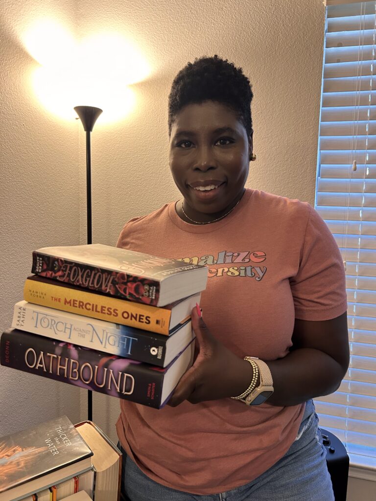 slow reading tips with me holding a small stack of potential books for my fall tbr